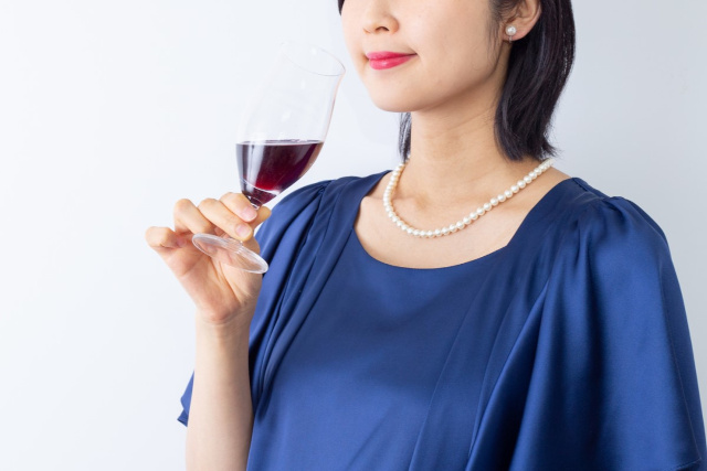 ワイングラスを持った青いドレスの女性